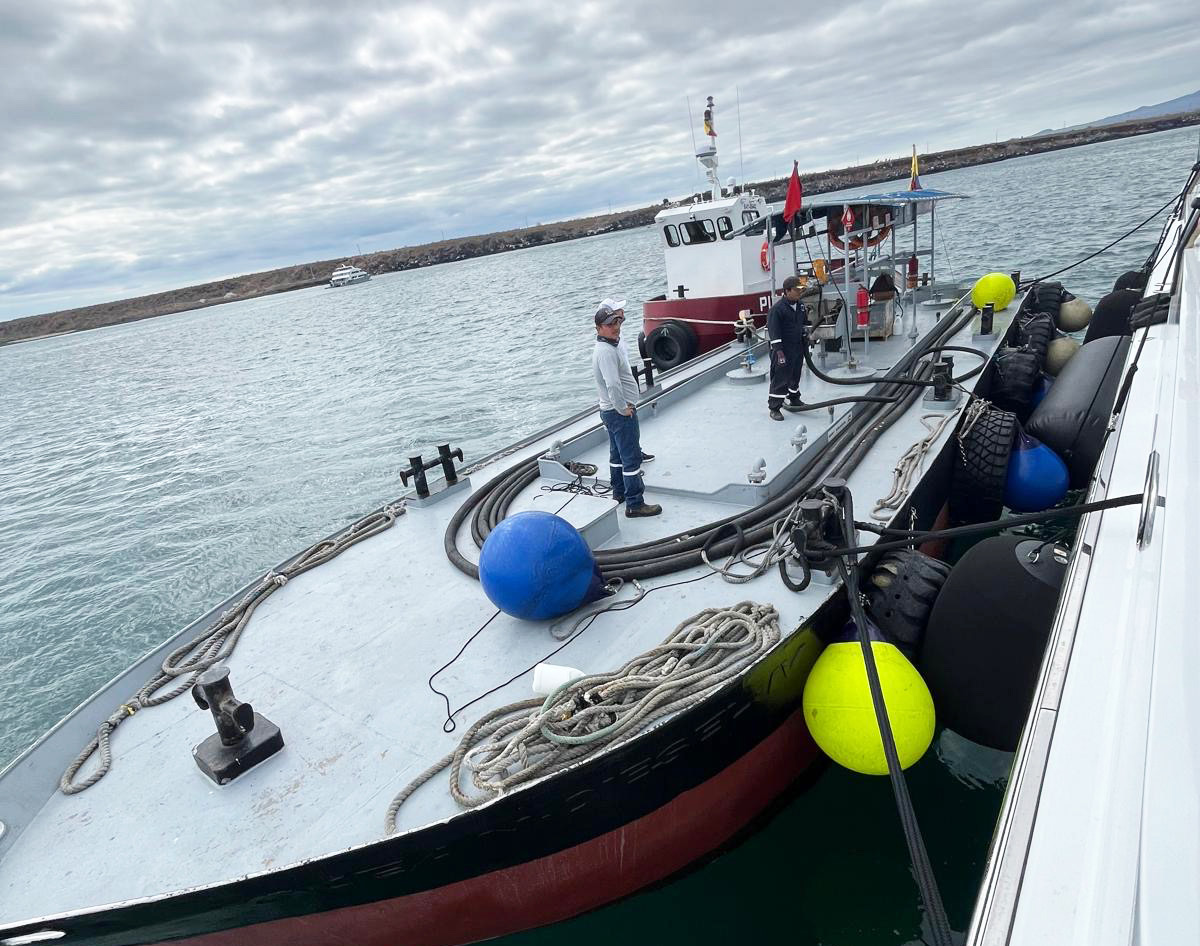 Crew handling fuel hoses on the deck of a bunkering vessel